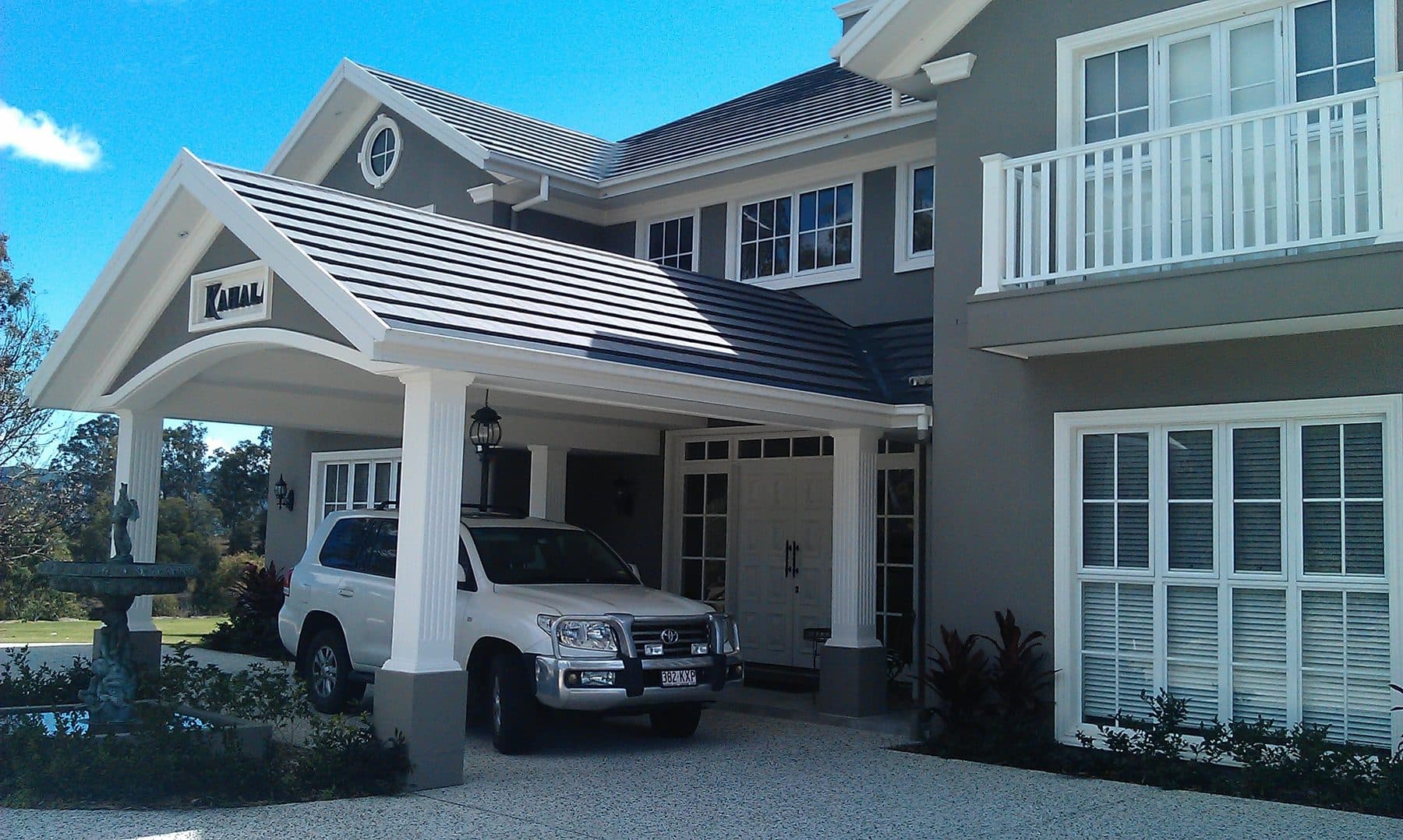 A rendered two-storey home with a portico, gutter guard fitted along the eaves